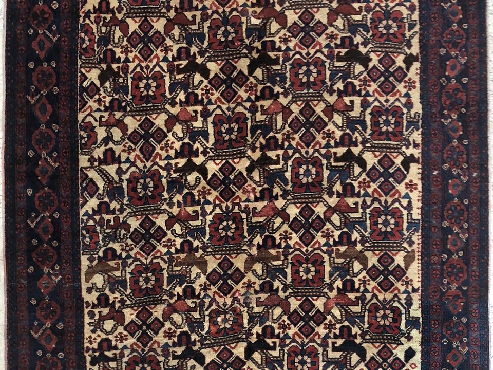 Antique rug detail showing softened colour and visible age in the wool